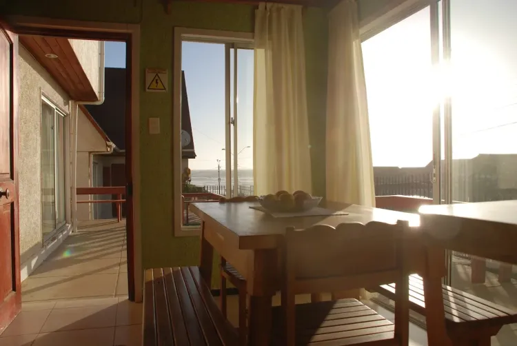 Comedor de la cabaña con mesa de madera y luz natural